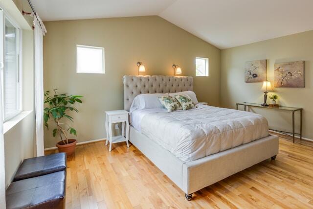 a bedroom with a light green accent wall and a large bed